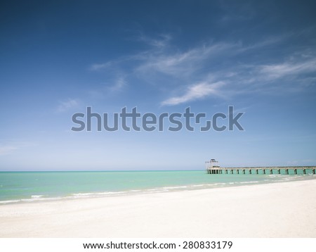 Summer sea beach with old pier