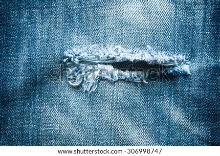 Blue denim jeans with tear closed up texture.