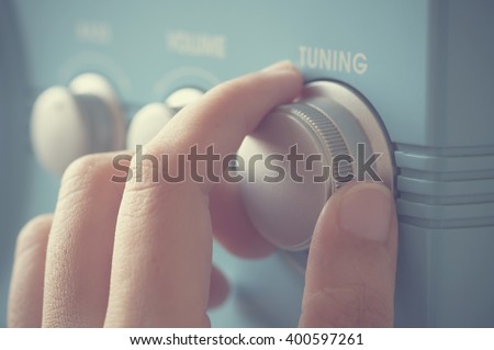 Hand tuning fm radio button. Retro image processed.