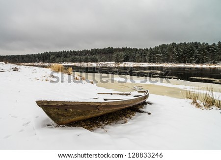 Winter rural landscape. The thrown boat brought by snow. Russia