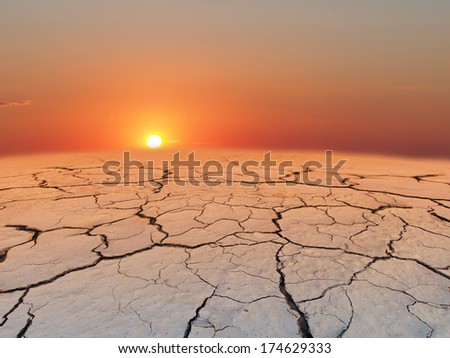 Cracked texture of the earth on sunset. Dry landscape.