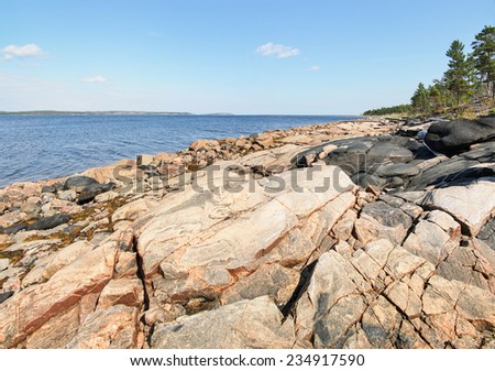 Rock sea coast at the sunny day. White Sea. Karelia. Russia