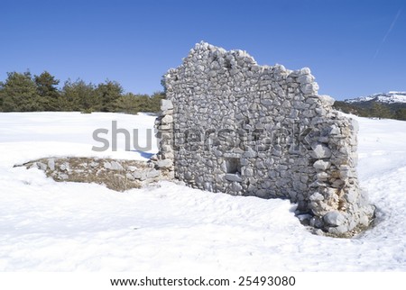 Old ruin in a field of snow. Part of a french village located in French Riviera