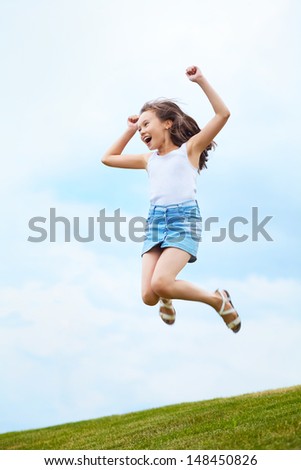 girl jumping for joy on sky background