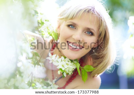 Outdoor Closeup Portrait Of A Beautiful Blonde Woman Among Blossom Apple Trees