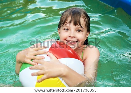 funny little girl in swimming pool. children outdoors