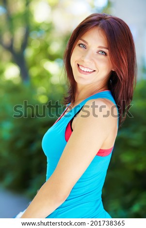 Portrait of sporty smiling woman on a green background. outdoor sports. sport lifestyle