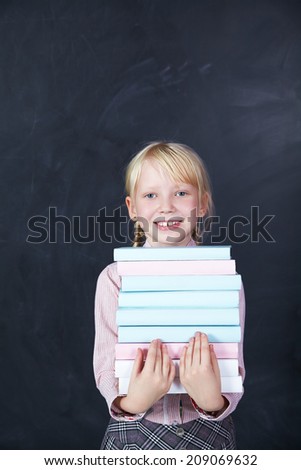 schoolchild with books in hand on background of boards. School and education