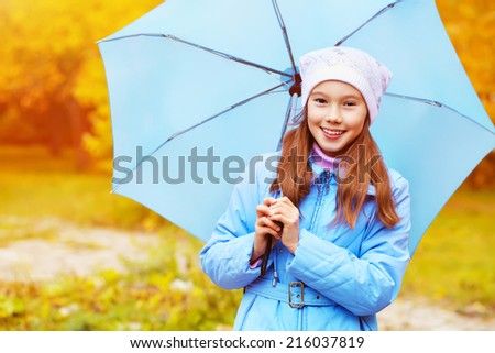 Portrait of a teenage girl walking in the park on a background of yellow autumn leaves