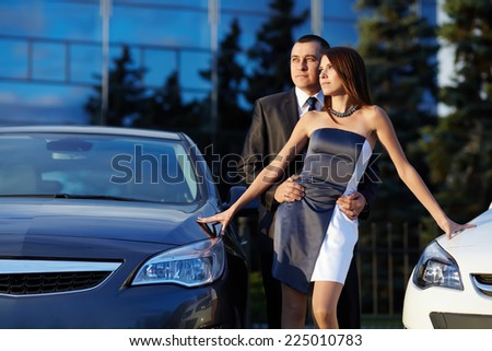 young couple standing near the car. choice car dealership