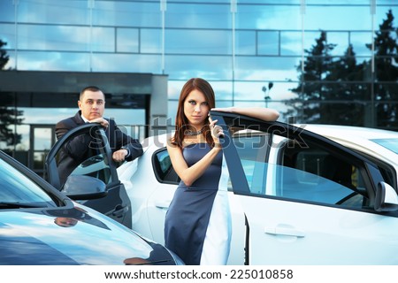 young couple standing near the car. choice car dealership