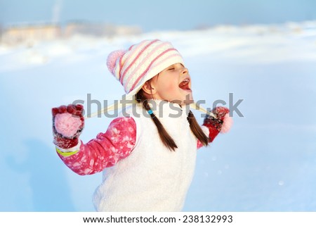 portrait of a girl walking in the winter outdoors. playing with snow. children outdoor