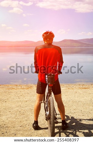 cyclist admires the scenic views of the mountain lake. man outdoors