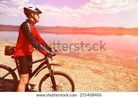 cyclist admires the scenic views of the mountain lake. man outdoors. mountain bike
