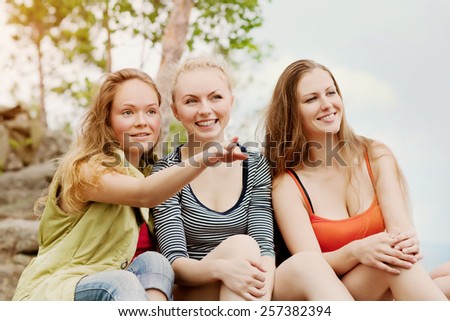 Three cute talking friends outdoors. female friendship
