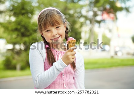 Portrait of a cute girl with ice cream on a walk in the park. child outdoors