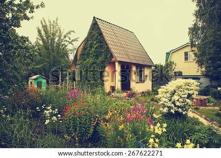 wonderful vintage rustic country house in the lush garden. garden flowers