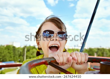 emotional girl in sunglasses in the amusement park. children outdoors. vacation in the summer park