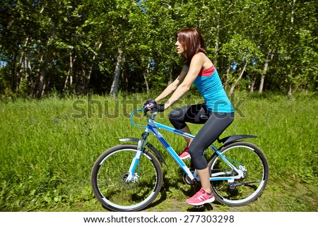 young woman riding a bike in a summer park. Active people outdoors. sport lifestyle