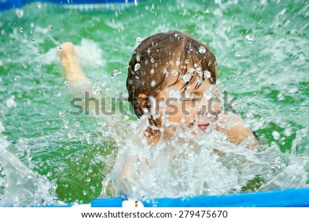selective focus. funny little girl splashing in the water in swimming pool. child outdoors