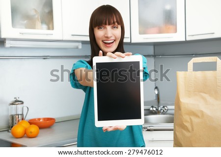 selective focus. young housewife uses a tablet computer in the kitchen. woman following recipe cooking vegetables on digital tablet. online food shopping