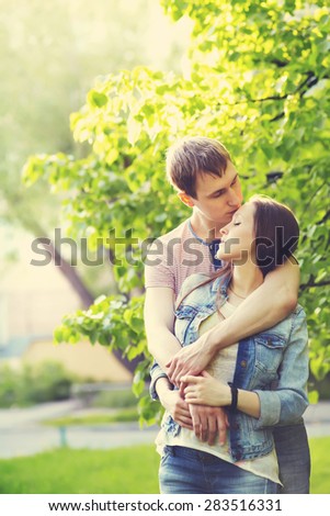 Young happy couple in love outdoors. loving man and woman on a walk in a summer park
