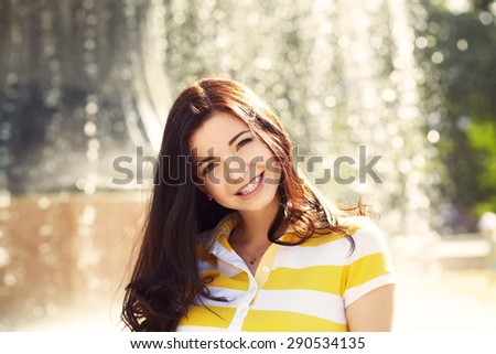 portrait of a beautiful smiling woman in a summer park. elegance casual model outdoors