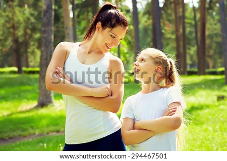 sporty mother and daughter. woman and child training in the park. outdoor sports. healthy sport lifestyle. fitness, yoga