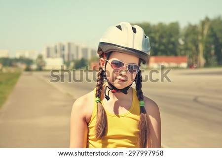 Little girl in helmet on the skates. sports child rollerskating in the city