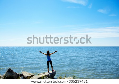 athletic woman on the background of the sea. freedom and a healthy lifestyle. harmonious person outdoors. the nature and vastness of the ocean. freedom