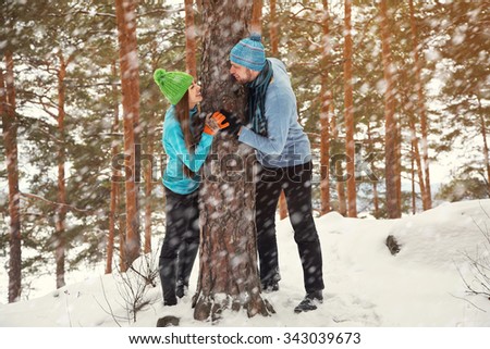 Young happy couple in love in the winter forest. Man and woman outdoors