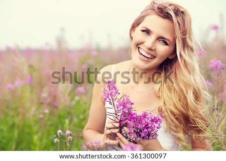 outdoor portrait of a beautiful middle aged blonde woman. attractive sexy girl in a field with flowers