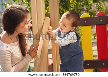 young mother playing with her baby on the playground. Mom and son