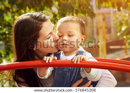 portrait of a young mother with her baby on the playground. Mom and son