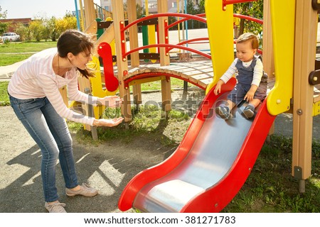 young mother playing with her baby on the playground. Mom and son