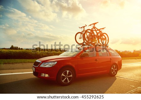 car is transporting bicycles on the roof. bikes on the trunk