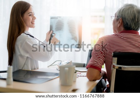 asian woman doctor consult and examine x-ray result with senior patient with care and focus