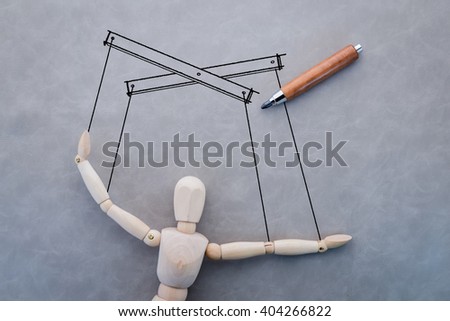 concept of business manipulating with wooden figure and drawing on grey background