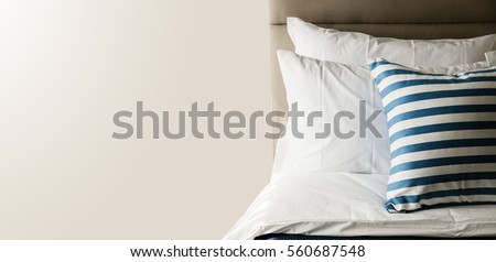 Bed maid-up with clean white pillows and bed sheets in beauty room. Close-up. Lens flair in sunlight.