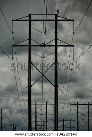 Group of Power lines with dark stormy sky in the background