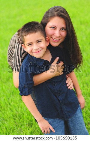 Beautiful mother hugging son outdoors in summer