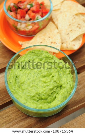 Bowl of guacamole made from fresh avocados, chips and salsa
