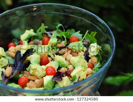 Mixed green salad with avocados, tomatoes, chickpeas and almonds