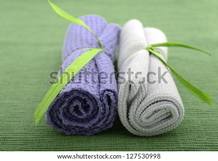 Purple and green wash cloths rolled up for bath at spa