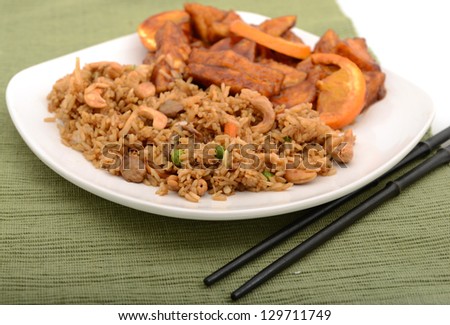 Fried rice and Tofu with orange peel sauce on a plate at an Asian restaurant