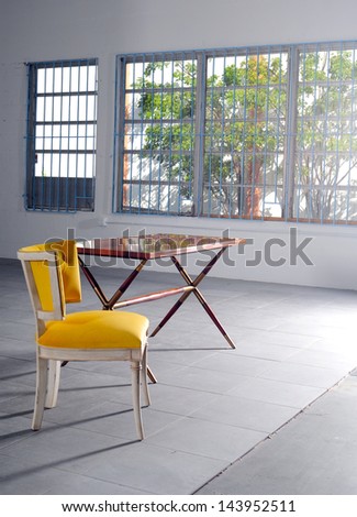 An empty yellow chair and table in minimalist loft