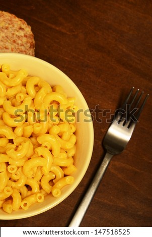 mac and cheese for meal with fork on wooden table
