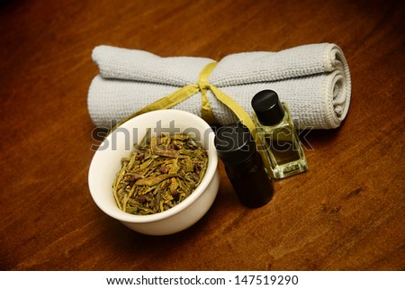 two bottles of essential oil with herbs and wash cloth for beauty treatment at spa