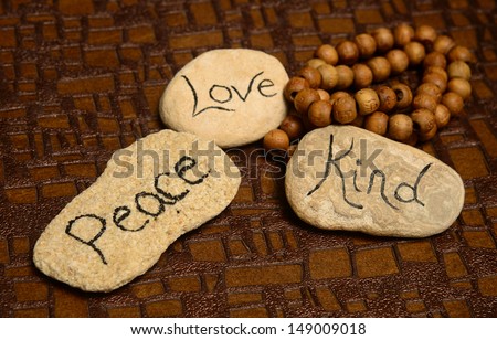 peace, love and kindness words on rocks for world peace