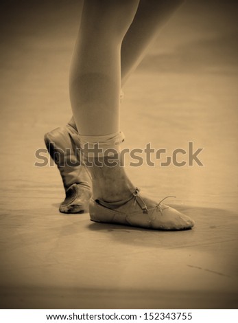 sore and battered ballet dancer\'s feet with bandaged and beat-up shoes